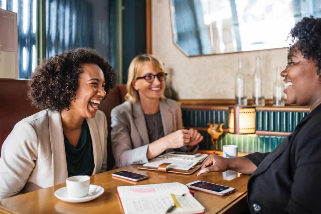 Image of 3 women in a social situation: having a friendly conversation and laughing