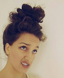 Image of a woman looking up at an oversized, giant bun. Hairstyles like this can cause headaches.