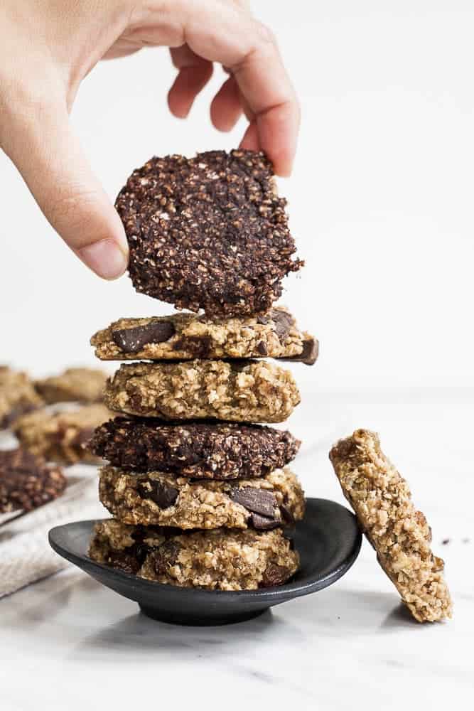 Image of brown and blonde banana peanut butter oatmeal cookies in a dark dish